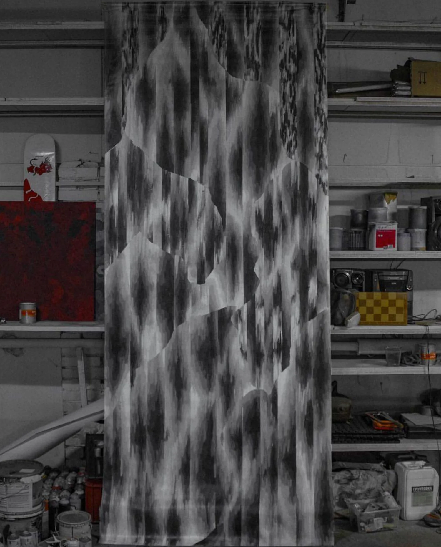 Storm Clouds: a tall canvas of grey spray-painted shapes in the studio