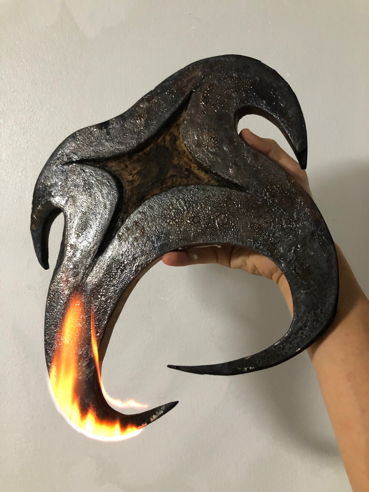 The same object held in hand, being charred with fire