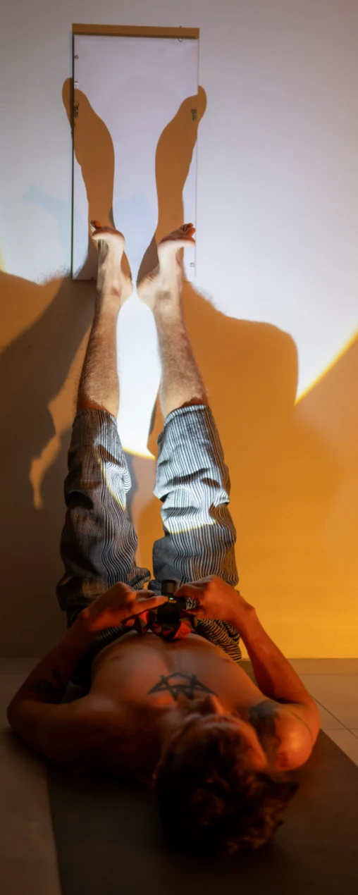 Legs raised against the wall, reflected light between them